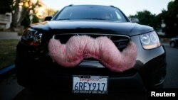 A driver with the ride-sharing service Lyft waits for a customer on a street in Santa Monica, California October 17, 2013. Lyft allows customers to book rides from a network of screened drivers.