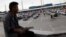 A man sits as cars queue up in multiple lines waiting to be inspected by U.S. border patrol officers to enter from Mexico into the U.S., at the San Ysidro port of entry, in Tijuana, Mexico, April 3, 2019. 