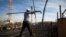 FILE - A laborer works on an apartment building project in a Jewish settlement known to Israelis as Har Homa and to Palestinians as Jabal Abu Ghneim in the West Bank.