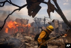 Vatrogasci u akciji. (Foto: AP/Etienne Laurent)