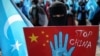 A protester from the Uyghur community living in Turkey holds up an anti-China placard during a protest against the visit of China's Foreign Minister Wang Yi to Turkey, in Istanbul, March 25, 2021.