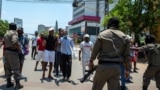 Polícias moçambicanos olham para os manifestantes que discutem com eles em Maputo, a 15 de janeiro de 2025, enquanto Daniel Chapo presta juramento para ser empossado como Presidente de Moçambique durante a sua tomada de posse na Praça da Independência.