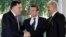 FILE - French President Emmanuel Macron stands between Libyan Prime Minister Fayez al-Sarraj (L), and General Khalifa Haftar (R), commander in the Libyan National Army (LNA), who shake hands after talks over a political deal to help end Libya’s crisis in La Celle-Saint-Cloud near Paris, France, July 25, 2017. 