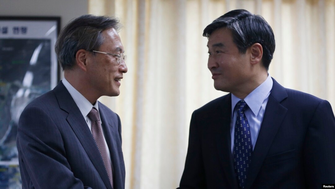 Junichi Ihara (kiri) juru runding nuklir Jepang untuk Korea Utara berjabat tangan dengan mitranya dari Korea Selatan Cho Tae-yong di Seoul (22/8/2013). Pemimpin Jepang dan Korea Selatan akan bertemu dengan Presiden AS dalam konferensi nuklir di Den Haag pekan depan. 