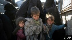 Para perempuan dan anak-anak anggota keluarga militan ISIS yang dievakuasi pasca jatuhnya kota Baghouz, Suriah dari kekuasaan ISIS (1/3). 