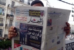 FILE - An Algerian man reads a local newspaper, En-Nahar, bearing a picture for the first time of former Algerian intelligence chief General Mohamed Mediene, better known as General Toufik, on the front cover in the capital, Algiers, Sept. 13, 2015.