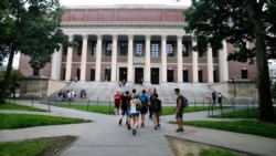 FILE - Students walk near the Widener Library in Harvard Yard at Harvard University in Cambridge, Mass., Aug. 13, 2019.