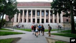 FILE - Students walk near the Widener Library in Harvard Yard at Harvard University in Cambridge, Mass., Aug. 13, 2019.