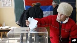 A woman casts her ballot at the polling station in Zvecan, Kosovo, February 14, 2012.