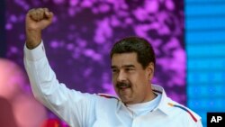 FILE - Venezuela's President Nicolas Maduro pumps his fist during a pro-government demonstration in Caracas, Venezuela, Feb. 12, 2019. 