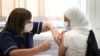 Seorang warga sedang divaksin COVID-19 di pusat vaksinasi di Belmont Health Centre di Harrow, London, Inggris, 6 Juni 2021. (Foto: Henry Nicholls/Reuters)