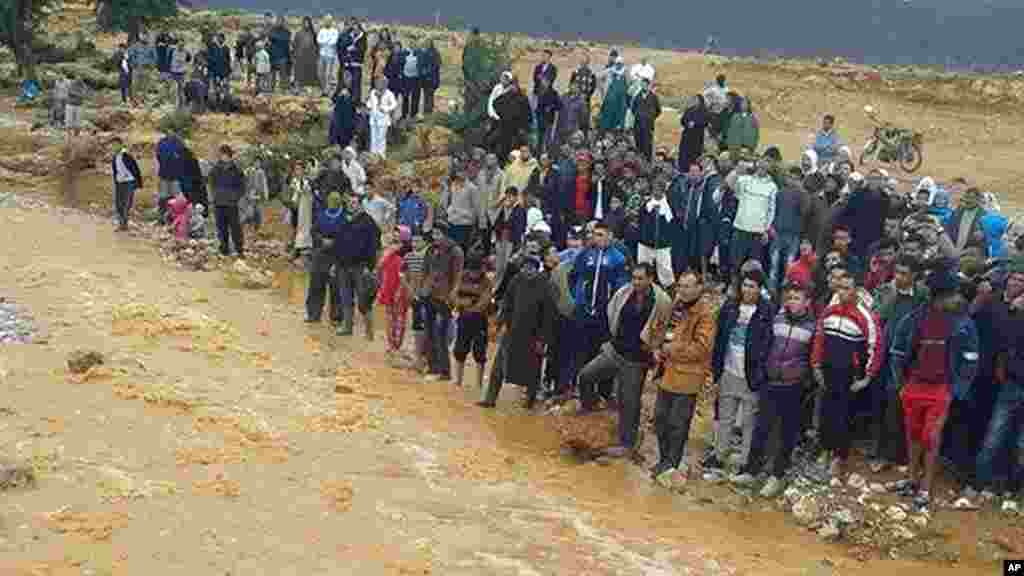 Cette image prise avec un téléphone portable montre des habitants de Guelmim, au sud ouest du Maroc, contemplant les eaux de crue, le lundi 24 novembre 2014.