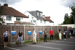 People queue outside a vaccination center for those aged over 18 years old at the Belmont Health Center in Harrow, amid the coronavirus outbreak, in London, June 6, 2021.