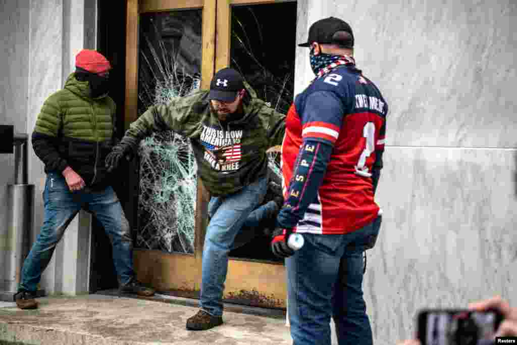 Far-right protesters break the door to the Capitol building during a protest against restrictions to prevent the spread of COVID-19 in Salem, Oregon, Dec. 21, 2020.