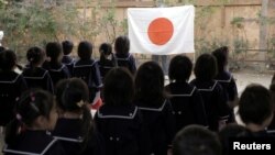 Students line up in front of Japan's national flag at the morning assembly at Tsukamoto kindergarten in Osaka, Japan, Nov. 30, 2016. 
