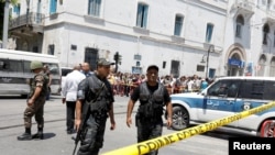 Police officers secure the site of a suicide bombing attack in downtown Tunis, Tunisia, June 27, 2019.