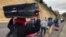 FILE - Venezuelan migrants walk along the Ecuadorean highway to Peru before new rules requiring they hold a valid passport kick in, at Tulcan, Ecuador, Aug. 21, 2018. 