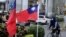 FILE - This photo taken Dec. 22, 2023, shows a cyclist next to two Taiwanese national flags in Taipei.