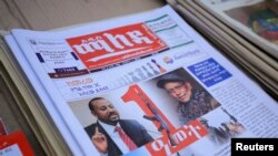 FILE - Ethiopia’s Prime Minister Abiy Ahmed and leader of the Tigray People's Liberation Front (TPLF) party Debretsion Gebremichael are pictured on a copy of a local newspaper, in Addis Ababa, November 3, 2021.