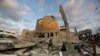 Orang-orang berdiri di luar masjid yang hancur akibat serangan udara Israel di Khan Younis, Jalur Gaza, Minggu, 8 Oktober 2023. (Foto: AP/Yousef Masoud)