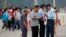 A security officer checks the identification cards of visitors at Tiananmen Square in Beijing, June 4, 2013. 