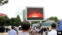 Quelques personnes regardent sur un écran géant le lancement d’un missile à longue portée à Pyongyang, Corée du Nord, 29 juillet 2017. 