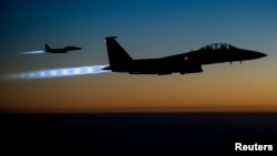 Un par de aviones F-15E de Estados Unidos vuelan en el amanecer sobre Siria.