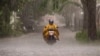 A man rides a motorcycle amid heavy rainfall in Surabaya on Nov. 29, 2024. 