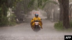 A man rides a motorcycle amid heavy rainfall in Surabaya on Nov. 29, 2024. 