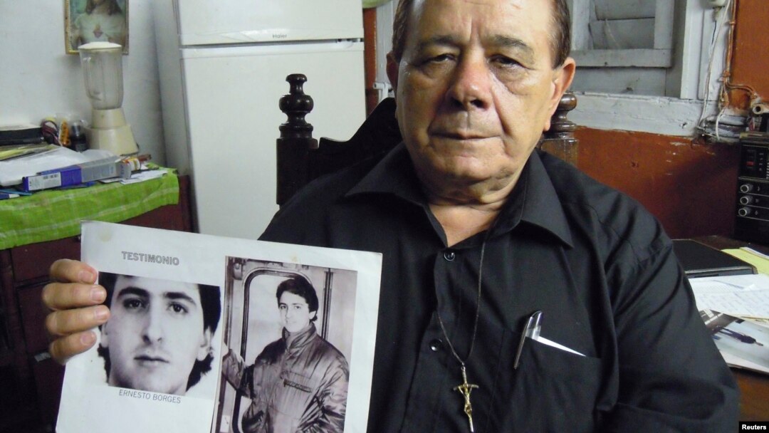 Raul Borges, 74, memegang foto anaknya Ernesto Borges di rumahnya di Havana (2/1). Ernesto telah dipenjara di Kuba selama 16 tahun setelah mencoba membocorkan rahasia ke seorang diplomat AS di Kuba. 