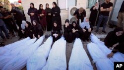  Palestinians mourn their relatives killed in the Israeli bombardment on the Gaza Strip, at Al Aqsa hospital in Deir el-Balah, Oct. 20, 2023.