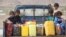 Children ride on the back of a truck loaded with water jerrycans at a camp for internally displaced people in the Dhanah area of the central province of Marib, Yemen, April 30, 2016.