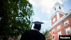 Seorang lulusan Harvard University bersiap mengikuti upacara kelulusan di kampus tersebut. 