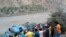 FILE - Local residents and rescue workers gather at the site of bus accident, in Kohistan Kohistan district of Pakistan's Khyber Pakhtunkhwa province, July 14, 2021. 