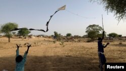 FILE - Sudanese refugees, who have fled the violence in Sudan's Darfur region, fly a handmade kite near the border between Sudan and Chad in Koufroun, Chad May 15, 2023. 