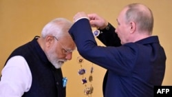 Russian President Vladimir Putin decorates Indian Prime Minister Narendra Modi with the Order of St. Andrew the Apostle the First-Called during a ceremony following their talks at the Kremlin in Moscow on July 9, 2024. (Photo by Alexander NEMENOV / AFP)