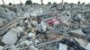 An unidentified boy goes through the rubble of a demolished small to medium business centre in Chitungwiza, 9 km (5 miles) south of Harare, Zimbabwe, June 22, 2005. 