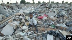 An unidentified boy goes through the rubble of a demolished small to medium business centre in Chitungwiza, 9 km (5 miles) south of Harare, Zimbabwe, June 22, 2005. 