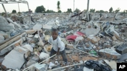 An unidentified boy goes through the rubble of a demolished small to medium business centre in Chitungwiza, 9 km (5 miles) south of Harare, Zimbabwe, June 22, 2005. 