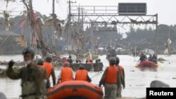 Local residents are rescued by Japanese Self-Defense Force soldiers using a boat at a flooded area after heavy rain in Kuma village, Kumamoto prefecture, southern Japan, July 5, 2020. (Kyodo/via Reuters)