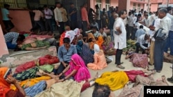 La gente se encuentra junto a los cuerpos de las víctimas de una estampida frente a un hospital en el distrito de Hathras en el estado norteño de Uttar Pradesh, India, el 2 de julio de 2024.