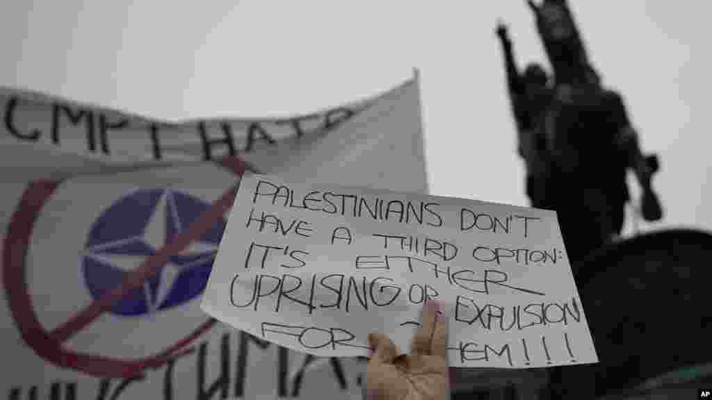 Un manifestante ondea una bandera contra la OTAN que dice: &quot;&iexcl;Muerte a los fascistas de la OTAN!&quot; durante una manifestación a favor de los palestinos en Belgrado, Serbia, el 5 de octubre de 2024.