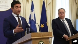 Macedonian Foreign Minister Nikola Dimitrov, left, speaks next to Greek Foreign Minister Nikos Kotzias during a news conference after their meeting in Athens, June 14, 2017.