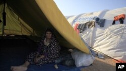 A Libyan refugee who fled unrest in Libya sit inside her tent at a refugee camp near the southern Libyan and Tunisian border crossing of Dehiba May 8, 2011.