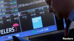 Traders work near the post where Goldman Sachs is traded on the floor of the New York Stock Exchange, July 16, 2015. 