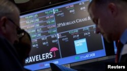 Traders work near the post where Goldman Sachs is traded on the floor of the New York Stock Exchange, July 16, 2015. 