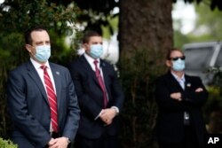 Members of the U.S. Secret Service stand at their posts as President Donald Trump speaks about the coronavirus during a press briefing in the Rose Garden of the White House, May 11, 2020.