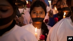 FILE - Indian women participate in a candle light vigil at a bus stop where the victim of a 2012 deadly gang rape had boarded the bus on what would become her final journey, in New Delhi, India, Dec. 16, 2014.