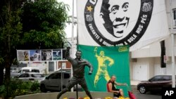Seorang pria duduk di sebelah patung Pele, bintang sepak bola Brazil di Santos, Brazil, Jumat, 30 Desember 2022. Pele meninggal dunia di São Paulo pada usia 82 tahun, 29 Desember 2022. (AP/Matias Delacroix)