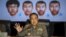 Thai national police chief Somyot Pumpanmuang gestures during a news conference about the Bangkok blast which killed 20 people, including foreigners, as a screen shows the different looks of a suspect, who has been referred to both as Bilal Mohammed and Adem Karadag, the name on a Turkish passport he holds, at the Royal Thai Police headquarters in central Bangkok, Thailand, Sept. 28, 2015.